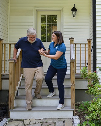 provider of respite care in Kennewick assisting senior patient down stairs