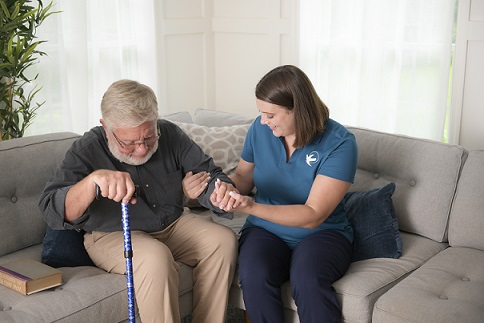 provider of home care in Kennewick assisting elderly patient on to couch
