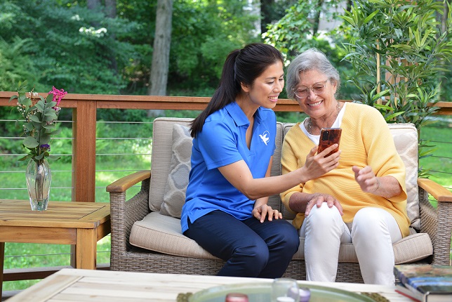 provider of senior care in Pasco looking at photo on mobile phone with elderly patient