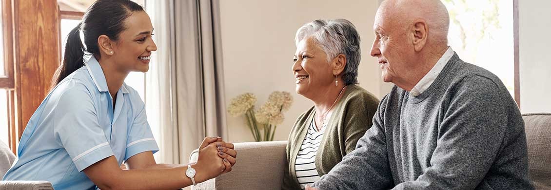 Female caregiver discusses how to start home care services with elderly couple.