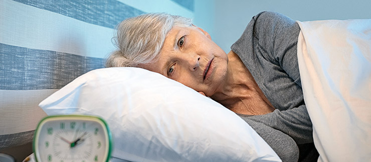 Worried senior woman in bed at night suffering from insomnia. 